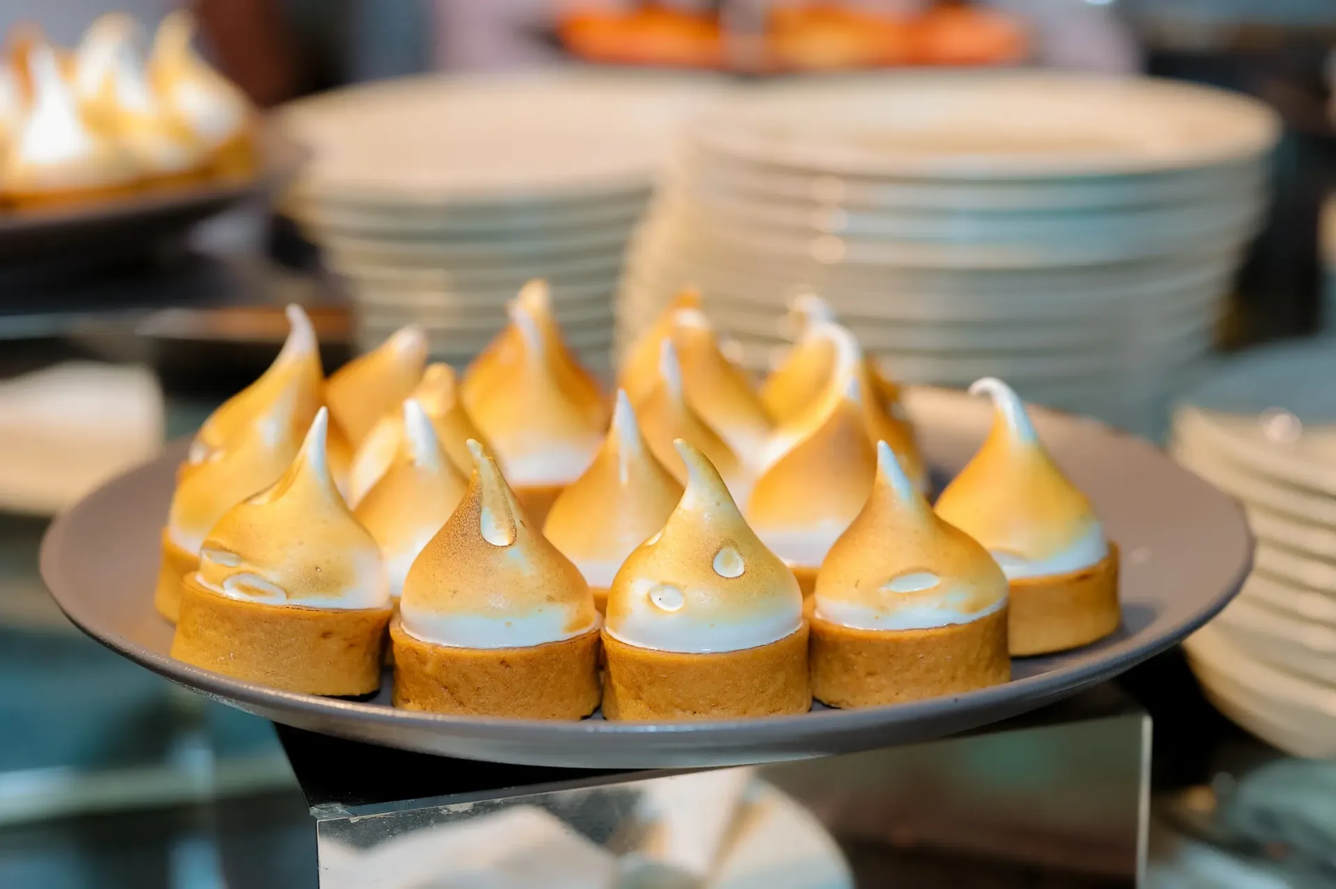 Artisan golden meringue tartlets displayed at luxury wedding dessert station
