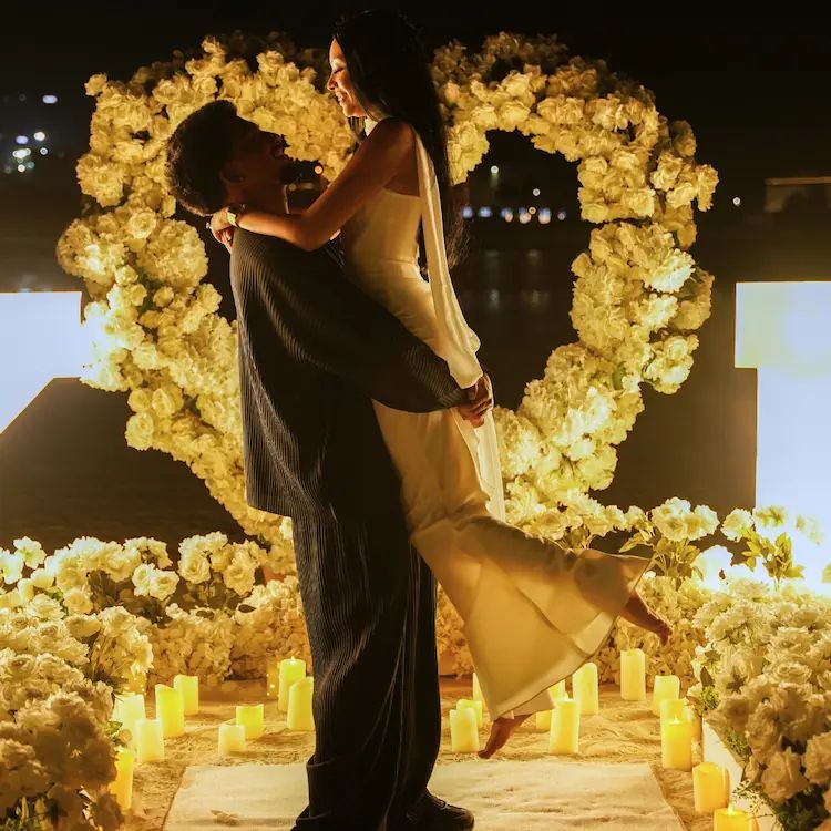 Romantic luxury wedding proposal on Kite Beach Dubai with a heart made of white roses and candles